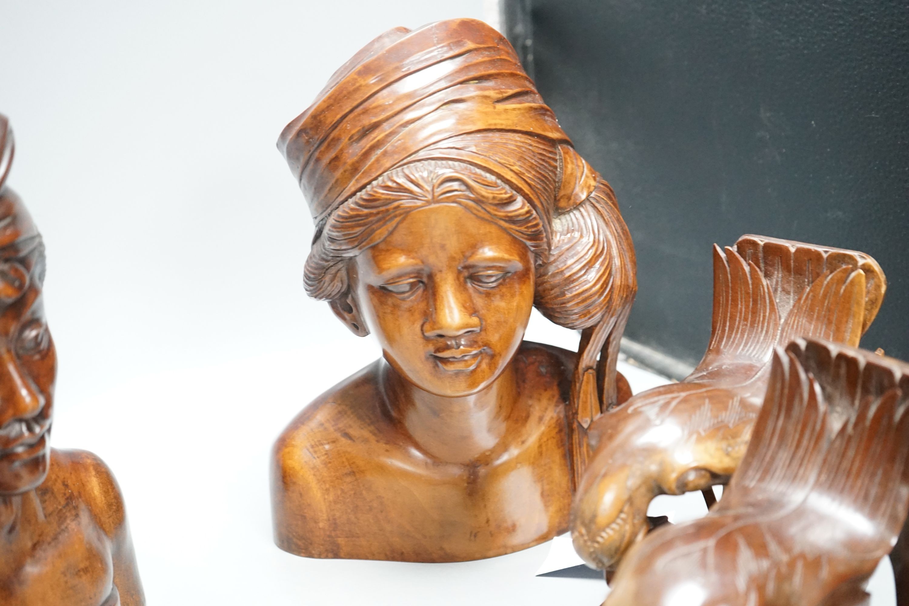 A pair of carved bird bookends ,and two pairs of carved Balinese busts